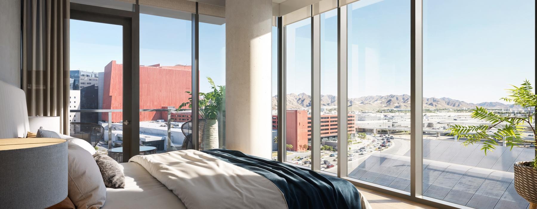 a room with a large window and a bed with a view of the city