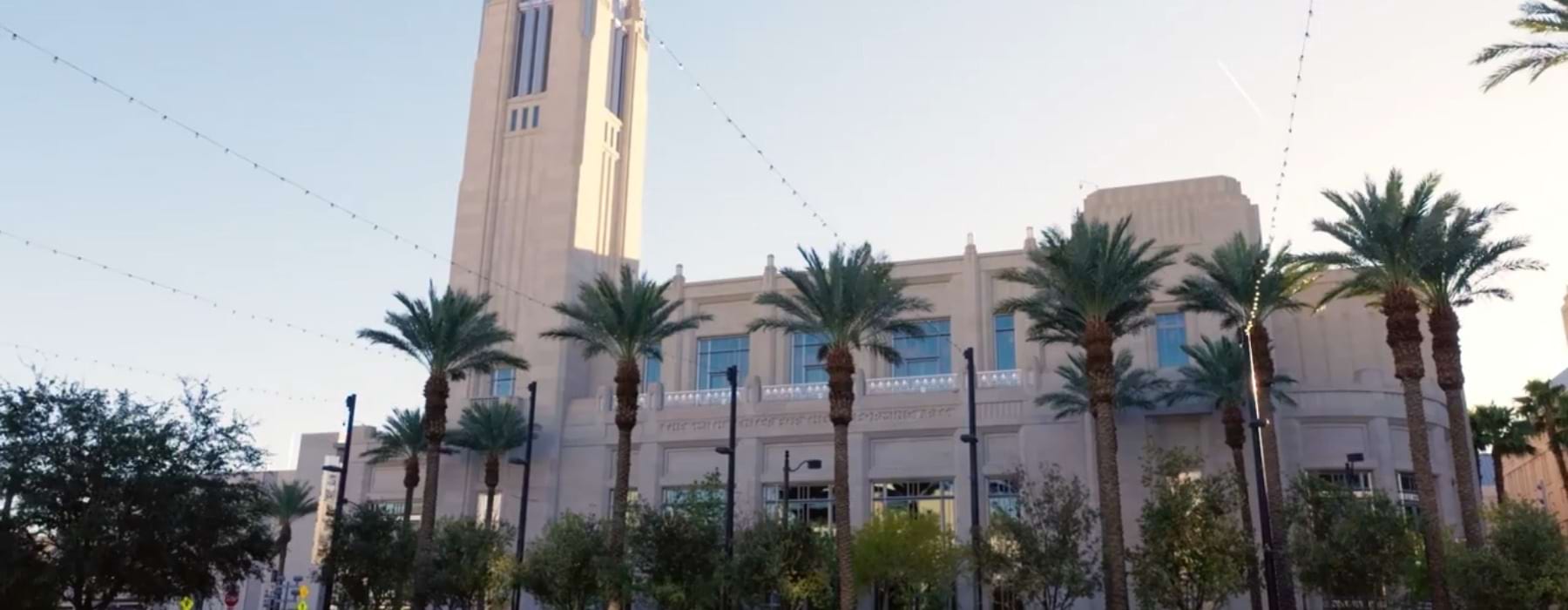 a large building with palm trees in front